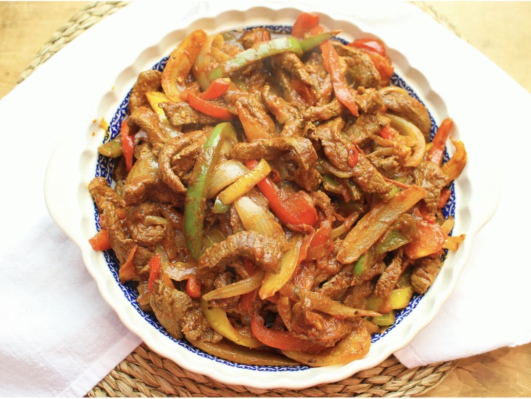 A vibrant platter of Ethiopian beef tibs with peppers and onions